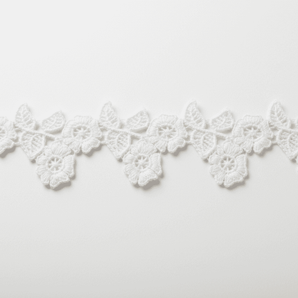 Pasamanería Macramé Blanca Flor 30 Yardas de Tiendas Lupe con diseño floral detallado, ideal para decoración de vestidos y manualidades elegantes.